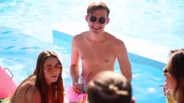 Groupe multiracial d'amis toasts, verres à cliquet avec cocktails à la fête de la piscine. Jeunes gens heureux en maillots de bain dansant, clubbing avec flamant rose gonflable, matelas dans un complexe de luxe. — Video