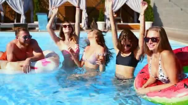 Ingerichte vrienden hebben pool party dansen met opblaasbare matras, watermeloen floaty speelgoed. Aantrekkelijke hete mooie glamour vrouwen in bikini en zonnebril veel plezier ontspannen, chillen op zonnige zomerdag. — Stockvideo