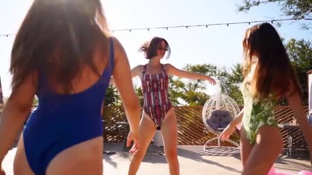 Hete mooie meisjes in bikini dansen met opblaasbare drijvers bij het zwembad. Aantrekkelijk ingerichte vrouwen in zwempakken hebben plezier in ontspannen, clubben op zonnige dag zomerfeest in luxe resort. Langzame beweging. — Stockvideo
