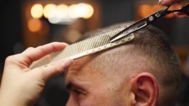 Çekici berber kız erkek saçını makas ve tarakla kesiyor. Müşteri hizmetinde çalışan kadın kuaför. Klasik berber koltuğunda oturan şık bir adam. Kuaför kadın moda saç kesimi yapıyor..