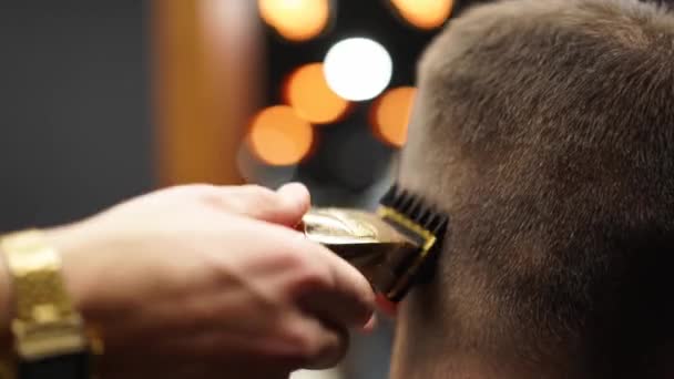 El peluquero moderno corta el cabello de los hombres barbudos con un cortador en la barbería. Para hombre peinado y corte de pelo en el salón. Aseo el cabello con trimmer. Peluquería haciendo corte de pelo en peluquería retro. — Vídeos de Stock