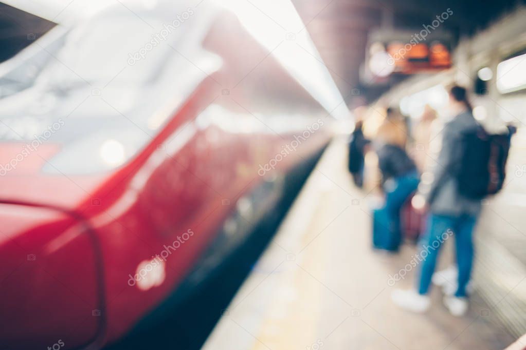 Blurred passenger at railway station traveling by train.