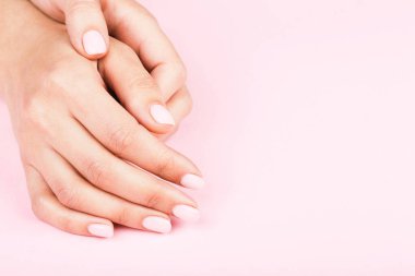 Klasik pastel manikürlü kadın elleri..
