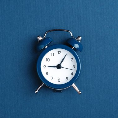 Koyu mavi zemin üzerine çalar saat.