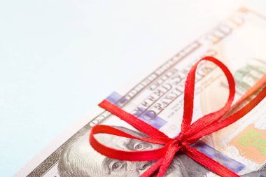 Kırmızı kurdeleyle bağlanmış dolar banknotları..