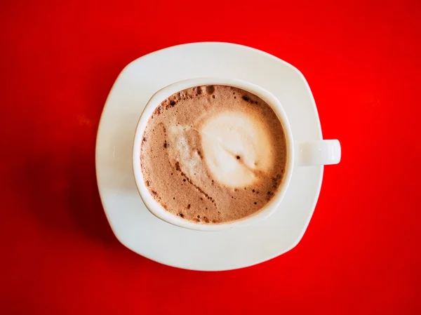 Kahve fincanı kırmızı masa üzerinde. — Stok fotoğraf