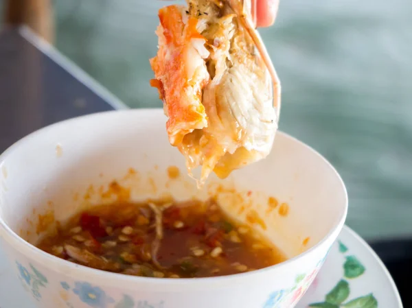 Dipping shrimp into spicy sauce. — Stock Photo, Image