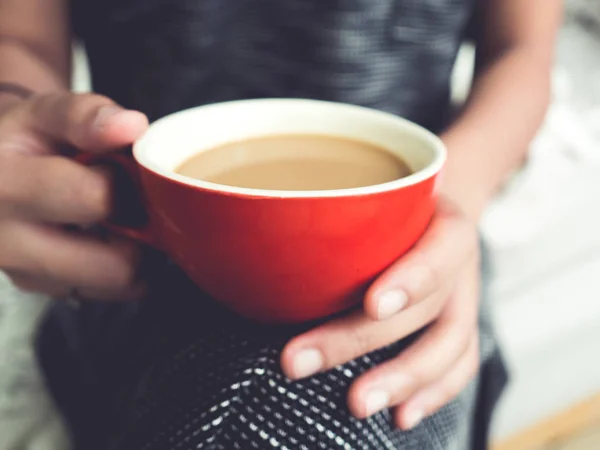 Frau hält eine rote Tasse Kaffee. — Stockfoto