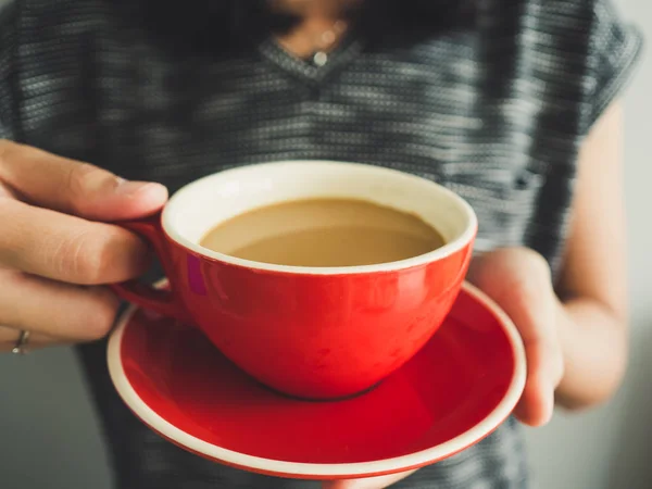Kobieta przytrzymaj czerwony kubek kawy. — Zdjęcie stockowe