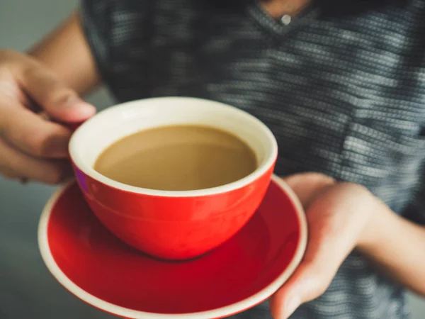 Frau hält rote Tasse Kaffee in der Hand. — Stockfoto