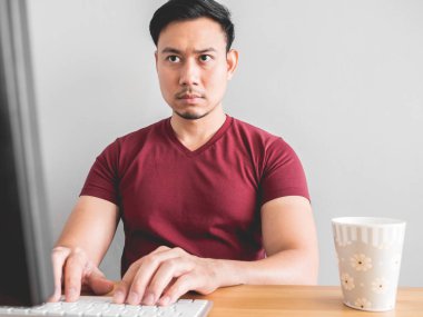 Ciddi Asya adam masada bir fincan kahve ile çalışma.