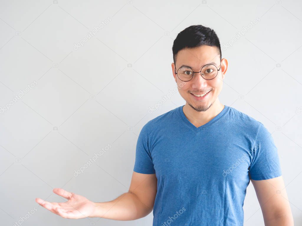 Happy Asian man is presenting something with hand point out to empty space.