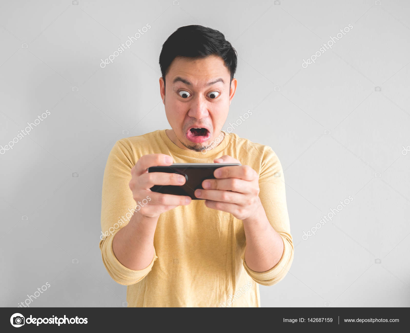 Asian Man Playing Mobile Game Seriously Stock Photo by ©sevendeman