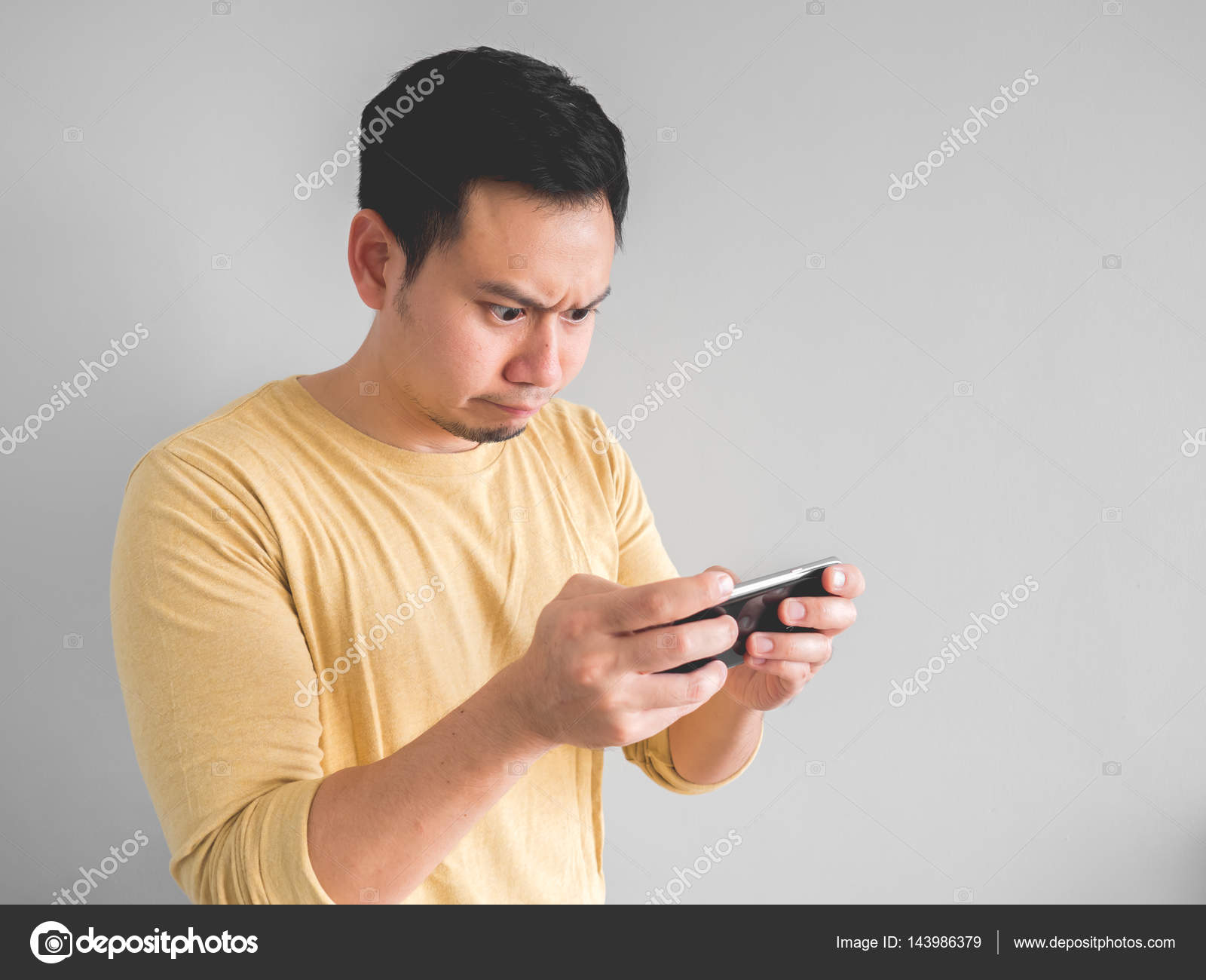 Asian Man Playing Mobile Game Seriously Stock Photo by ©sevendeman