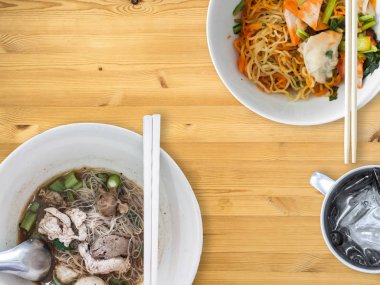 Şehriye çorbası Tay tarzı kurutulmuş domuz eti veya sığır eti ve Tay yumurta noodles ile paslanmaz bardak buzlu su ile görev.