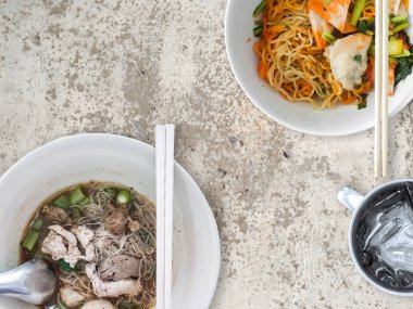 Şehriye çorbası Tay tarzı kurutulmuş domuz eti veya sığır eti ve Tay yumurta noodles ile paslanmaz bardak buzlu su ile görev.