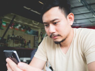 Cep telefonunuzun açık bir kafede Asya adam.