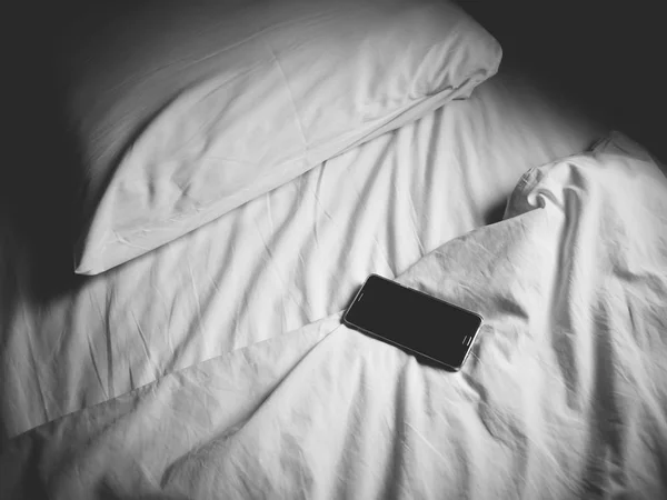 Smartphone or mobile phone on the bed. — Stock Photo, Image