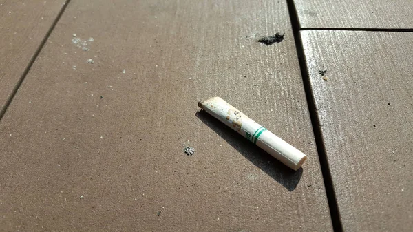 Cigaretta esett a padlón. — Stock Fotó