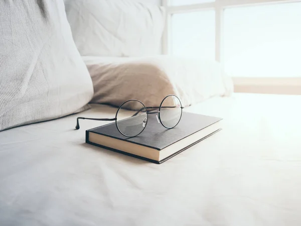 Lunettes de vue et livre dans la chambre pour lire et se détendre . — Photo