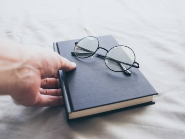 Gözlük ve yatak okumak için kitap ve rahatla.
