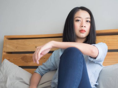 Kadın yalnız yatak ve bir şey düşünmeye oturur.