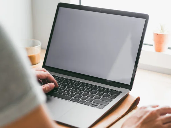 Man aan het werk op zijn laptop door de ramen met witte monitor. — Stockfoto