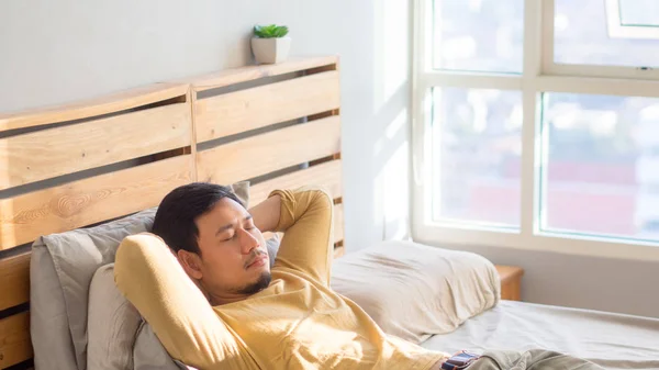 Hombre durmiendo en su cama al mediodía . — Foto de Stock