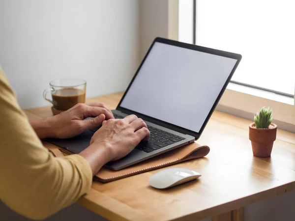 Kahve sabah ışık ile masa üzerinde dizüstü bilgisayar kullanan adam.