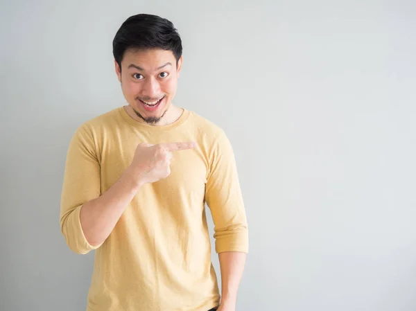 Man in yellow t-shirt excited to point and present an empty spac — Stock Photo, Image