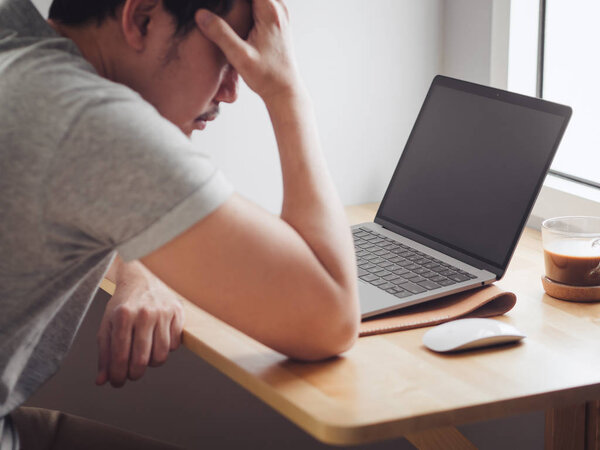 Serious man has problem working on laptop.