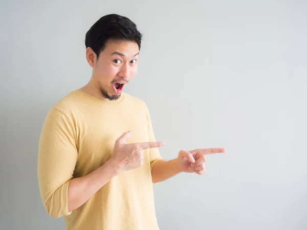 Man in yellow t-shirt excited to point and present an empty spac — Stock Photo, Image