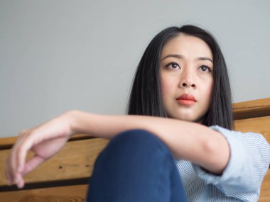 Kadın yalnız yatak ve bir şey düşünmeye oturur.