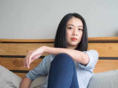 Kadın yalnız yatak ve bir şey düşünmeye oturur.