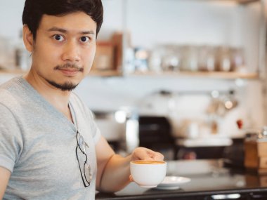 Adam kahve kafede sıcak kahve içiyor.