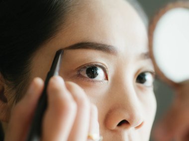 Kadın yapmak kaş kalemi ile kaşlarını koyarak