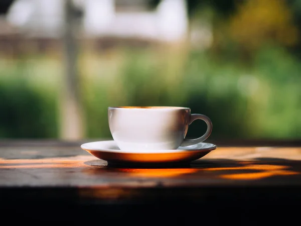 Taza caliente blanca de café Latte en mesa de madera en sombra . — Foto de Stock