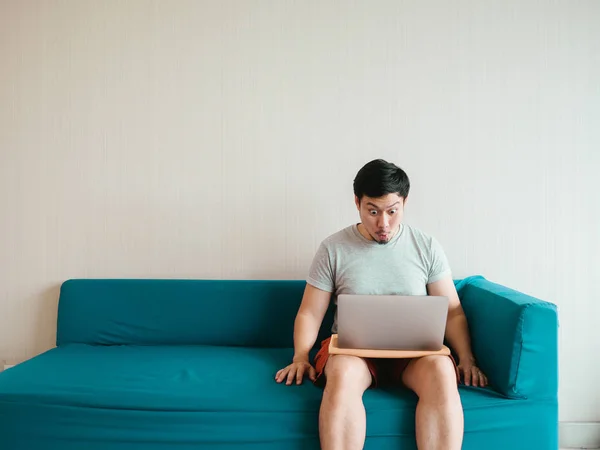 남자 그의 캐주얼 옷감에 소파에 노트북을 사용 하. — 스톡 사진