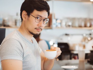 Adam kahve kafede sıcak kahve içiyor.