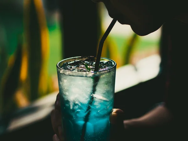 Femme boit un verre de soda au citron bleu glacé — Photo