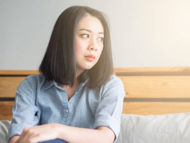 Kadın yatağında gün zamanında oturur..