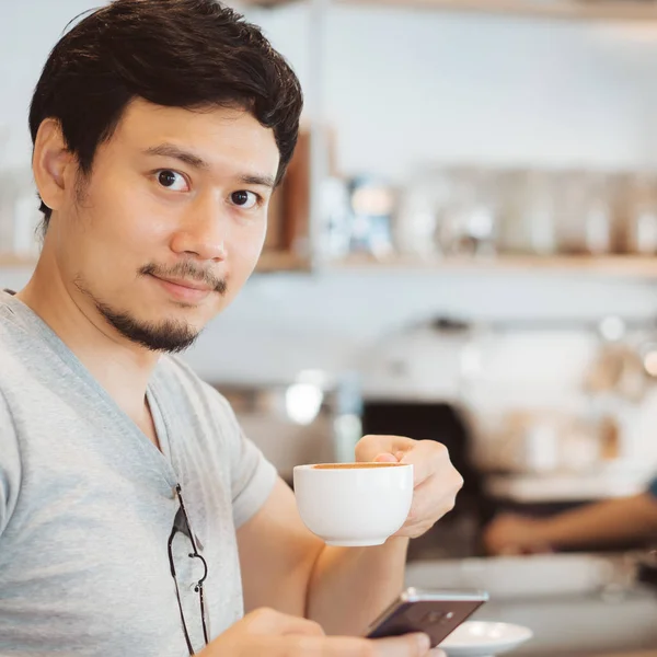 Mann trinkt heißen Kaffee im Kaffeehaus. — Stockfoto