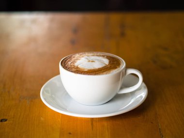 sıcak kahve latte sanatı ahşap masada.