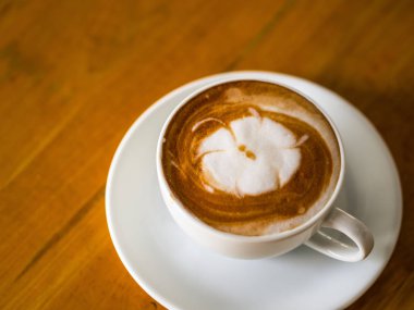 sıcak kahve latte sanatı ahşap masada.