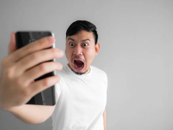 Chocado e assustador rosto do homem ficar gritado a partir de smartphone. Ver s — Fotografia de Stock