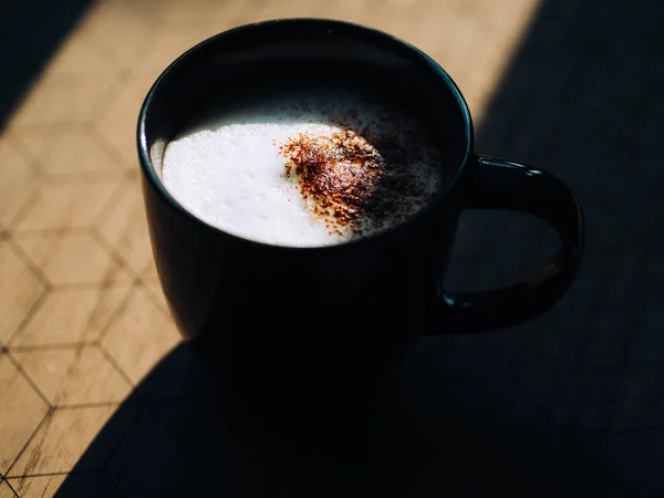 Μαύρο φλιτζάνι καφέ στο πρωινό φως από το παράθυρο. — Φωτογραφία Αρχείου