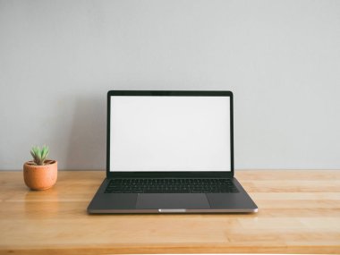 Laptop ve boş ahşap çalışma masası üzerinde sabit bazı araçlar 