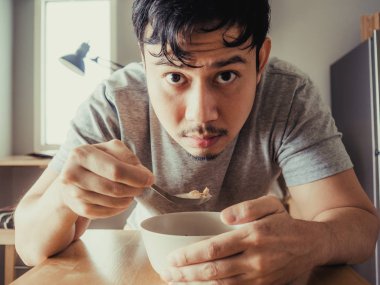 Adam kahvaltı Mısır gevreği sıkıcı bir bolw yaşıyor.