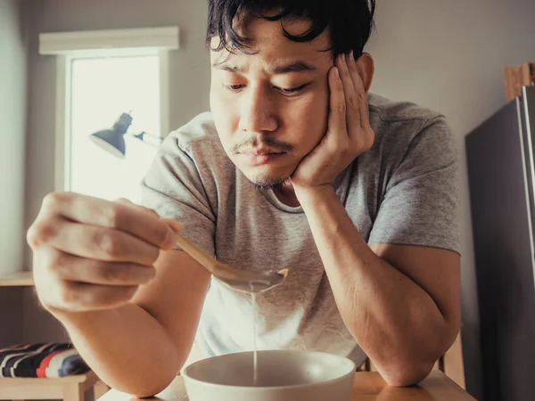 O homem está a comer cereais chatos ao pequeno-almoço. . — Fotografia de Stock