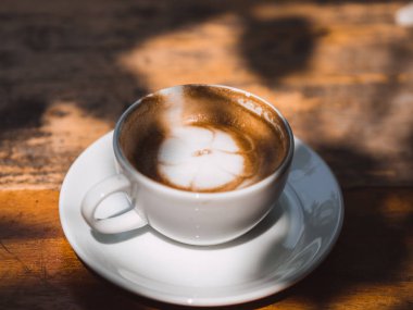 Beyaz fincan sıcak Latte Kahve gölge gölge ahşap tablo.